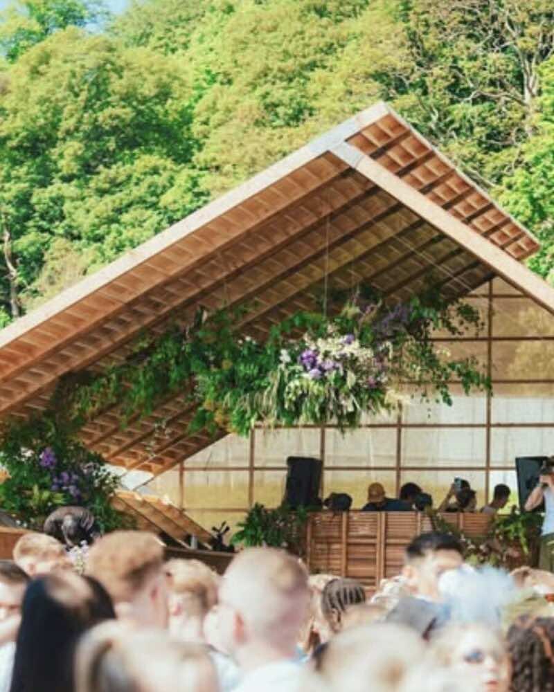 A hanging floral installation under a timber pavilion roof